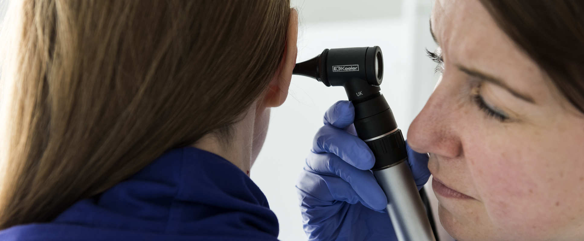 Person looks in patient's ear