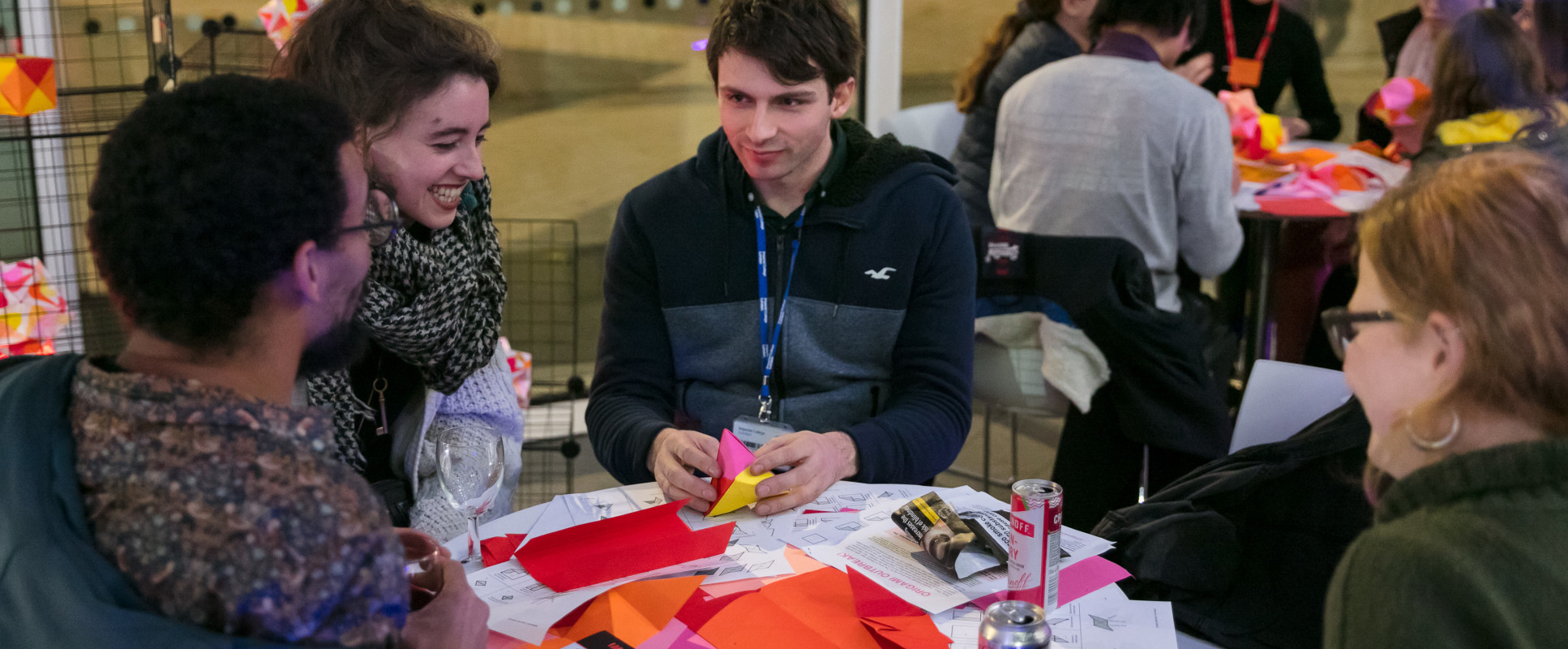 people sit at table with coloured paper