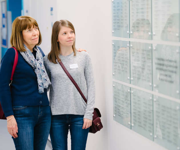 Mother and daughter looking at the the tribute wall