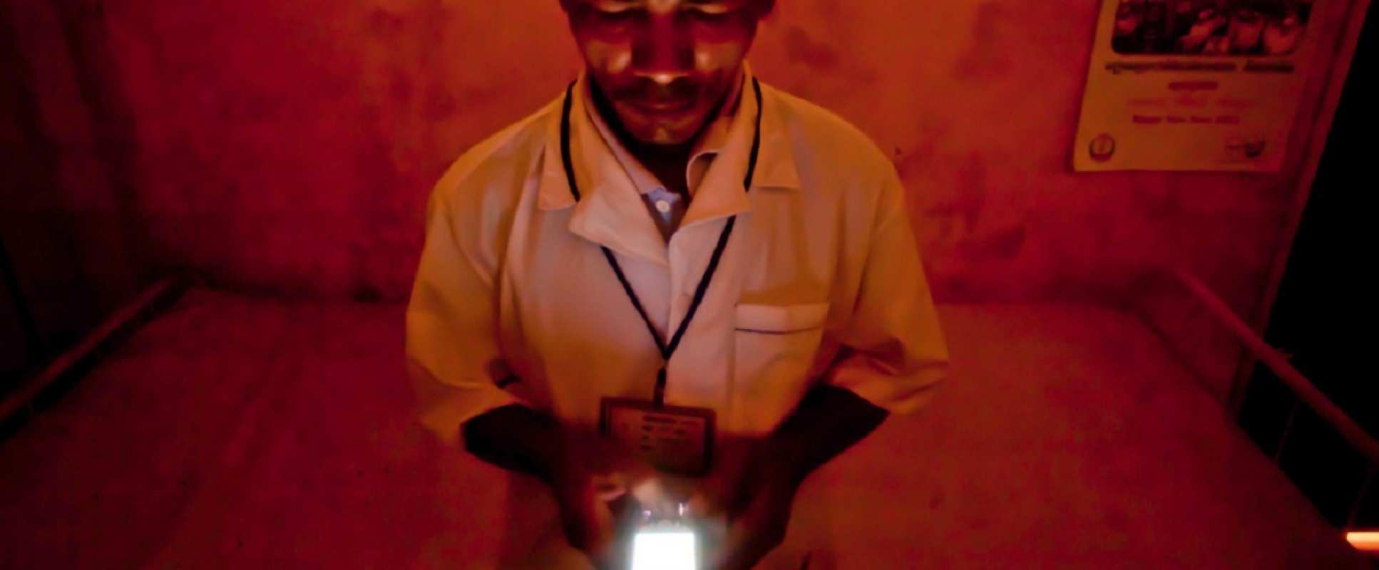 Member of medical staff using a mobile phone to report on malaria