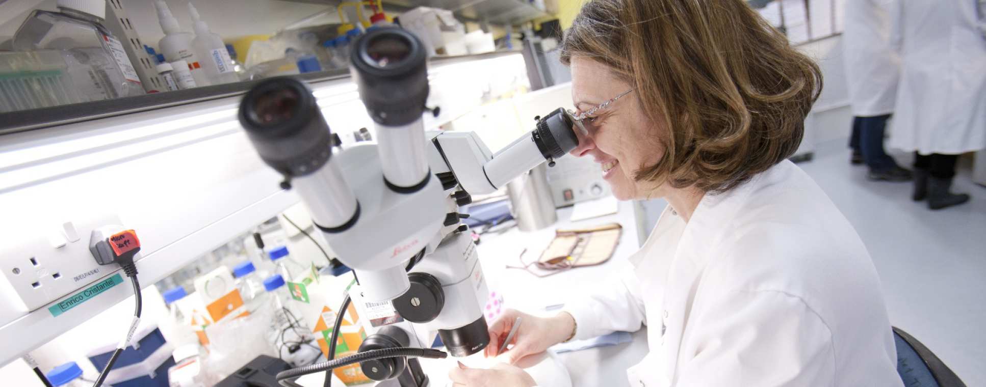A researcher examining specimens with HPRU microscopic equipment