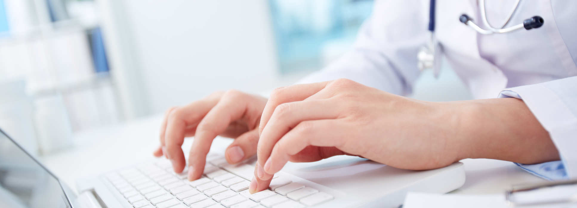 A nurse typing on a laptop