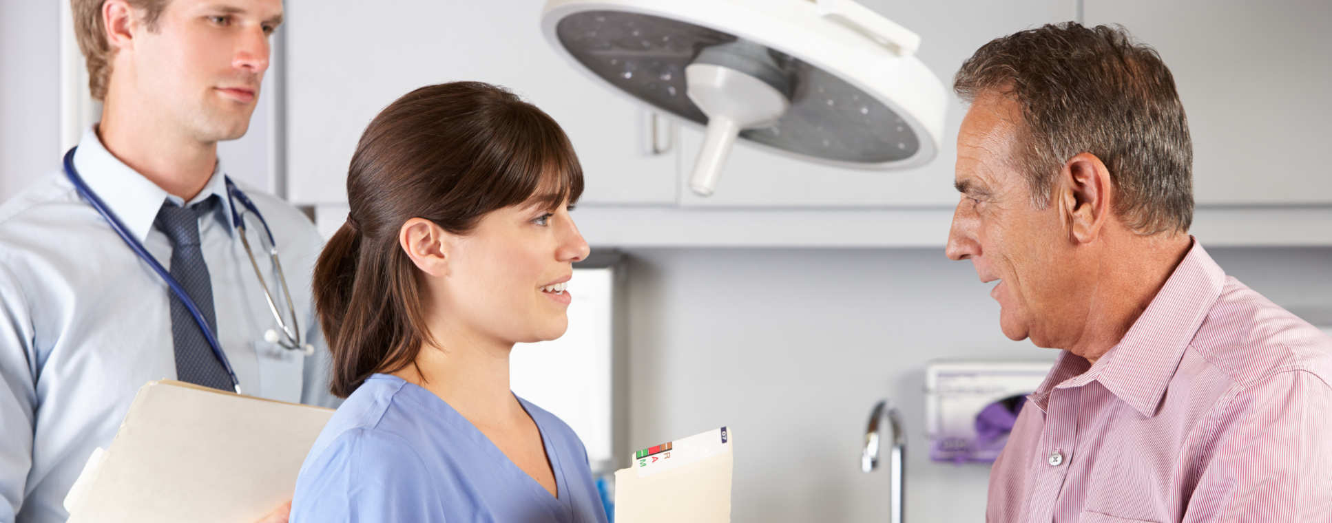 A doctor and trainee talking with a patient