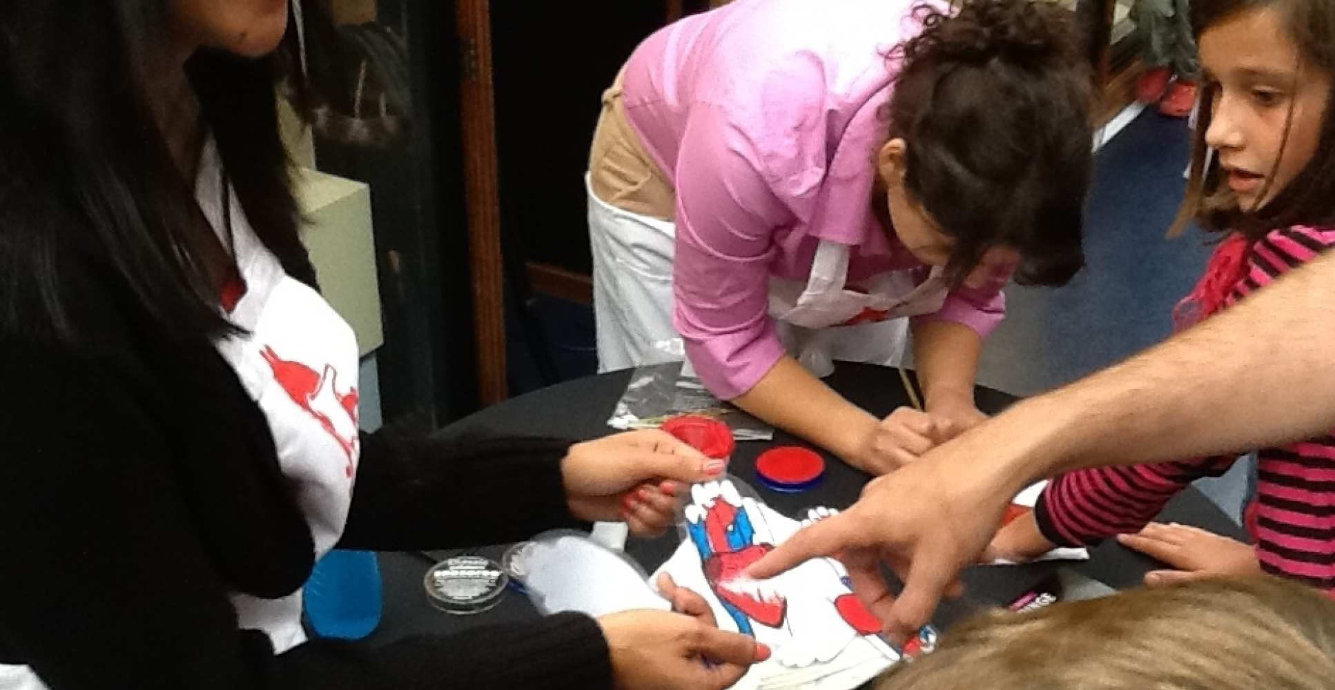 People have hearts painted on hands at museum