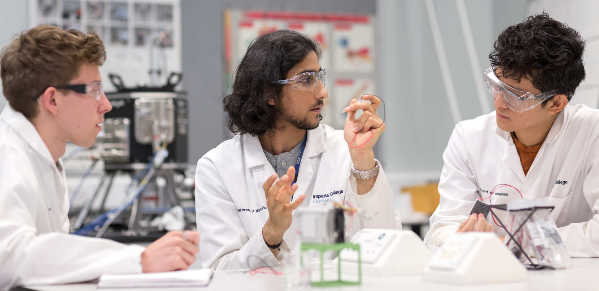 three students discussing a project in a lab