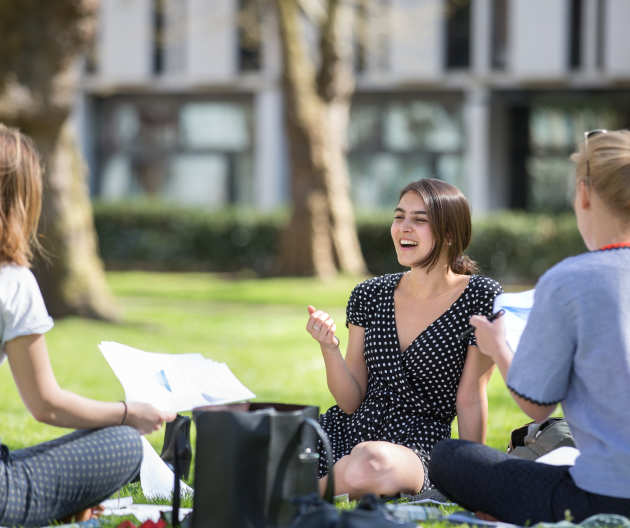 Students sitting and laughing on the grass