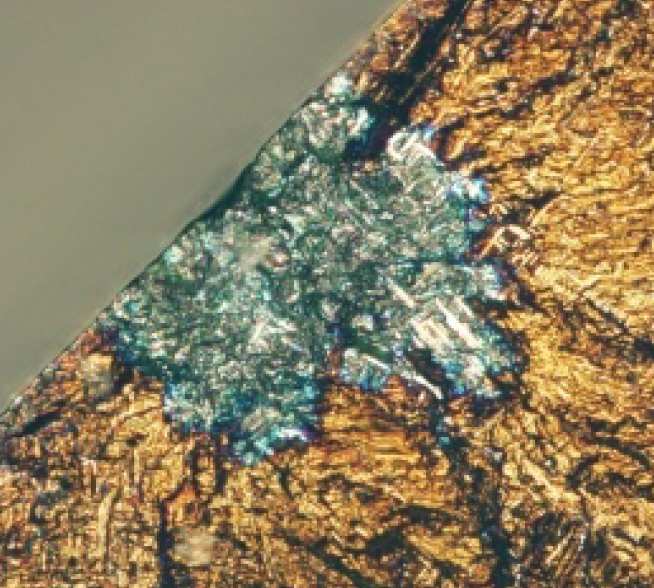   Light micrograph demonstrating the 'blue spot' at the fatigue crack origin