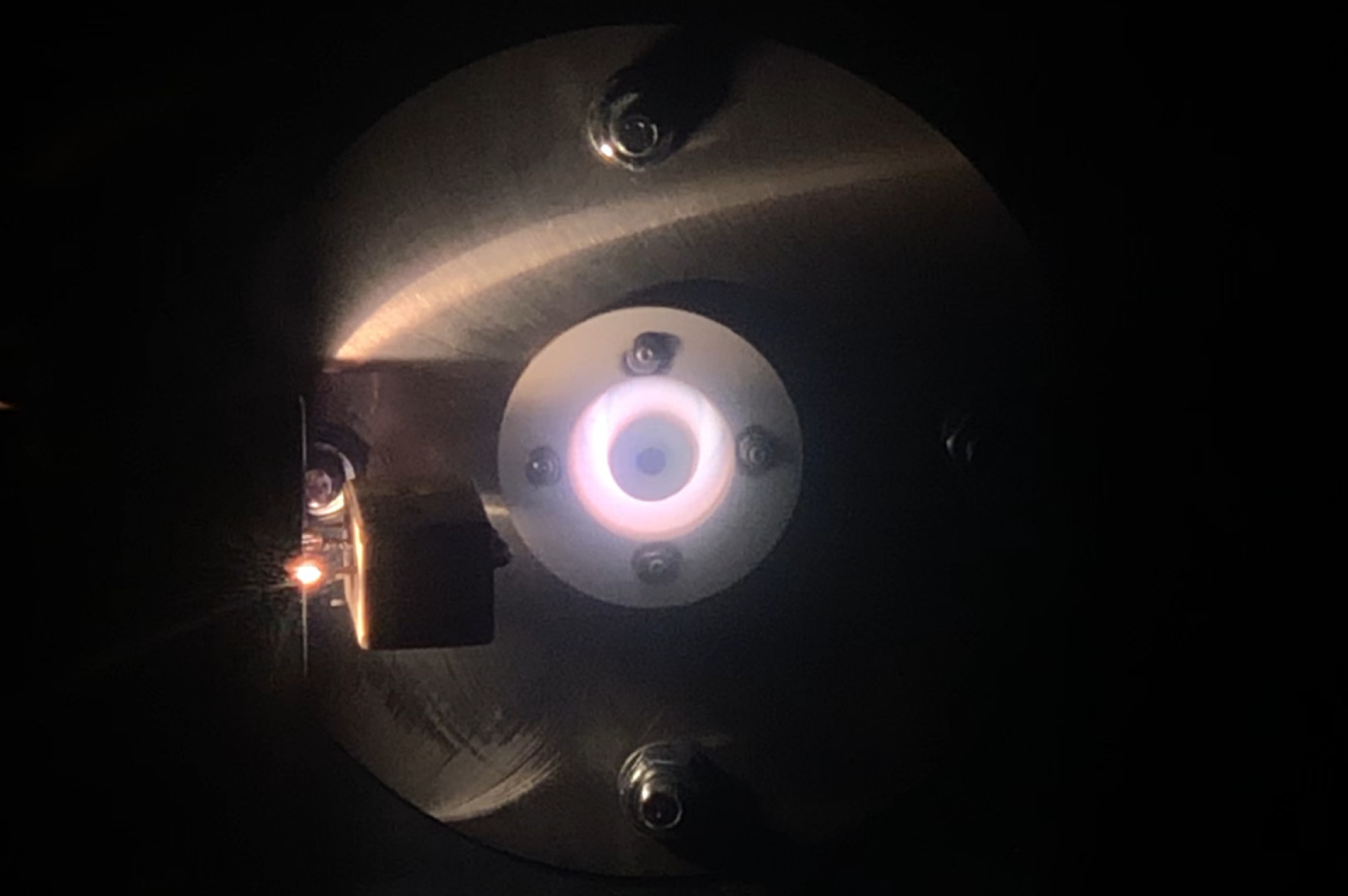 Frontal photo of WET-HET operating on oxygen at 500 W discharge power inside vacuum chamber