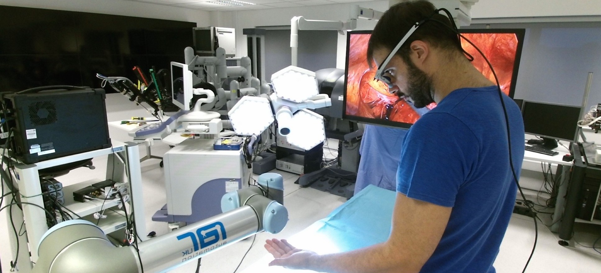 Man operating a research robot in an operating theatre