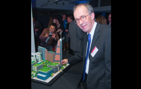 Deputy Rector Professor Stephen Richardson cutting a cake in the shape of the entire Imperial West Campus.