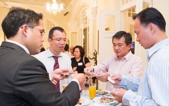 Business cards being exchanged at the alumni reception in Singapore