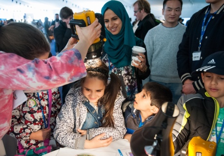 Kids and grown ups learning about light at the Imperial Festival