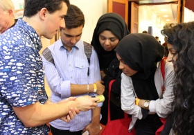 One of the research team showing students small plastics debris