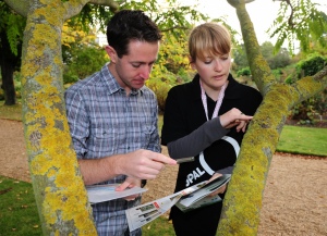 People looking at lichen on a branch