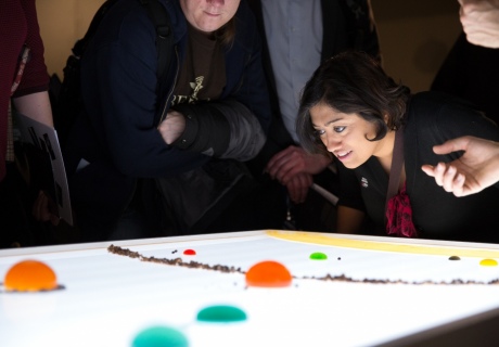 Woman looking at a white table holding jellies and food representing the solar system