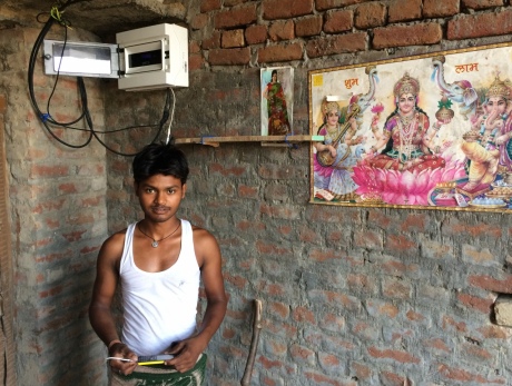 This villager is charging his phone at home, instead of 5 kilometres away which was previously the case