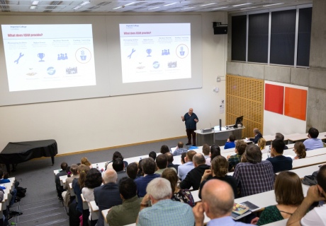 Professor Ces in front of a large lecture theatre crowd