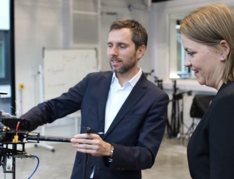 Baroness Sugg and Dr Mirko Kovac look at a drone