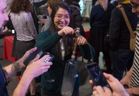 Visitor holds clear bottle with a cloud inside that she created