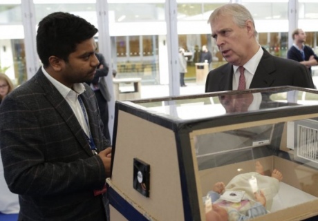 Malav Sanghavi discussing with a colleague next to a neonatal incubator made of cardboard. 