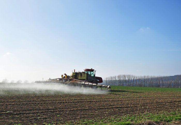 Farm vehicle spreading fertiliser