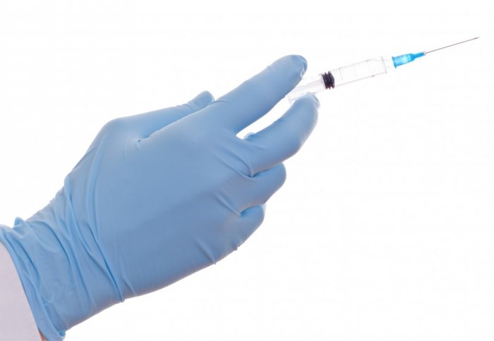 Healthcare professional holds vaccine needle