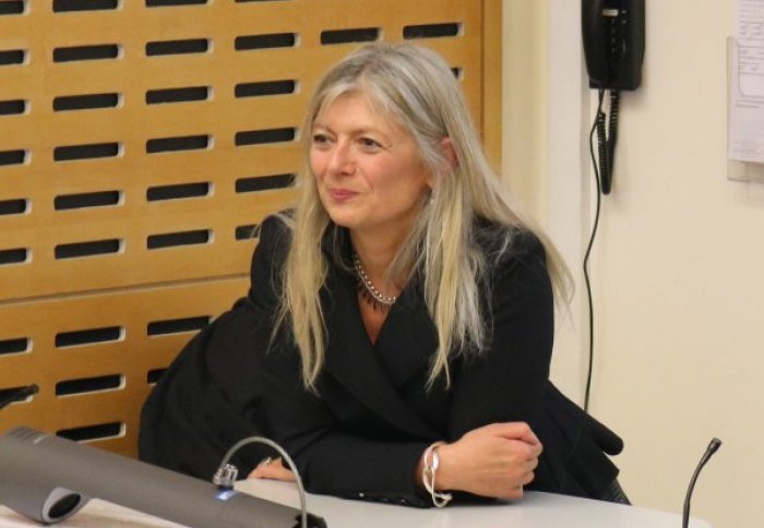 Barbara Casadei leaning on podium in lecture theatre smiling