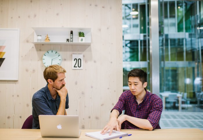 two young professionals discussing an idea in a modern and fashionable office environment