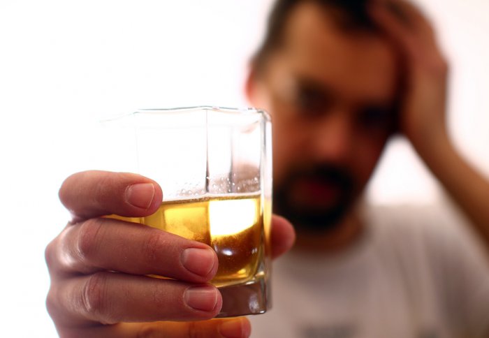Man raises an alcoholic drink to the camera lens