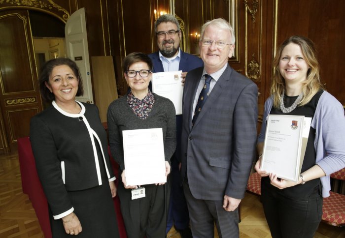 five people, three holding certificates