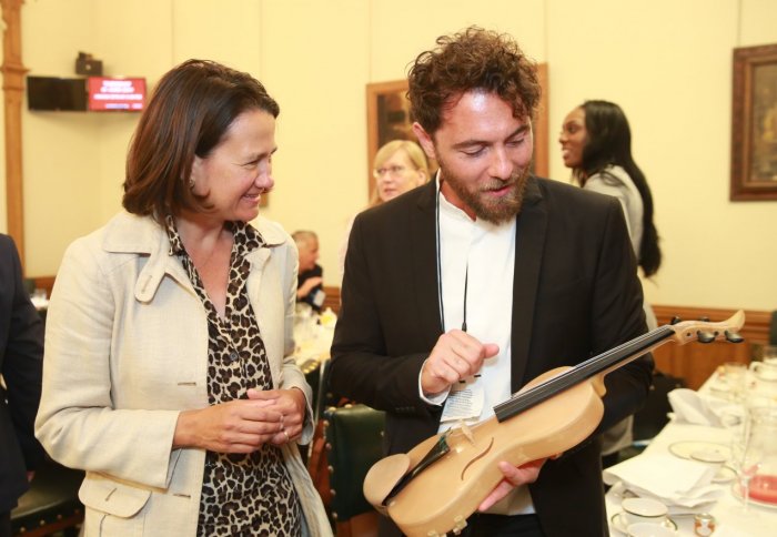 Luca demonstrates his violin to Catherine West MP