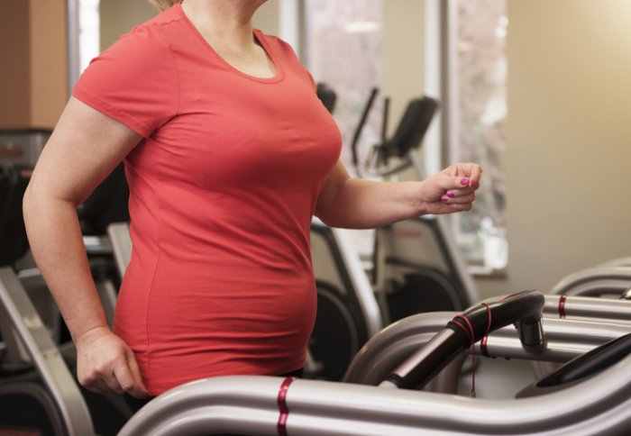 An overweight woman working out in a gym