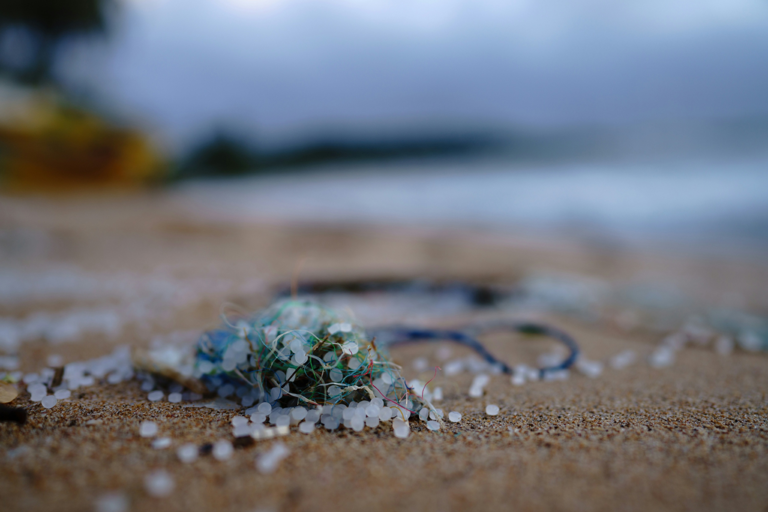 A close up photo of small plastic pieces on a beach