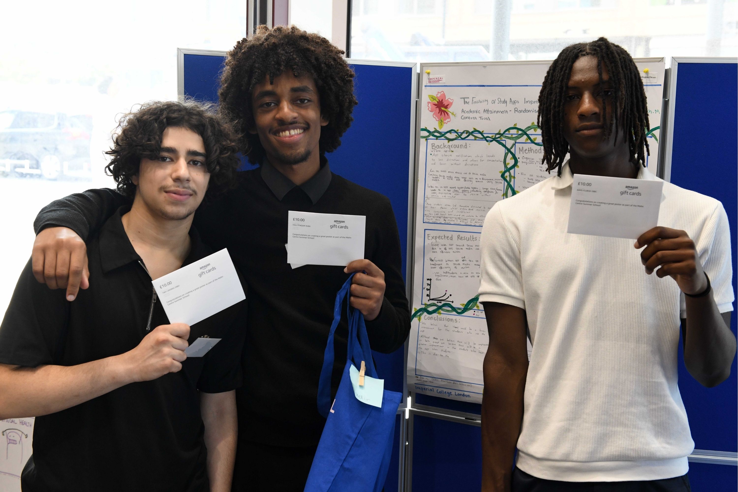 Three young people standing by their winning research poster