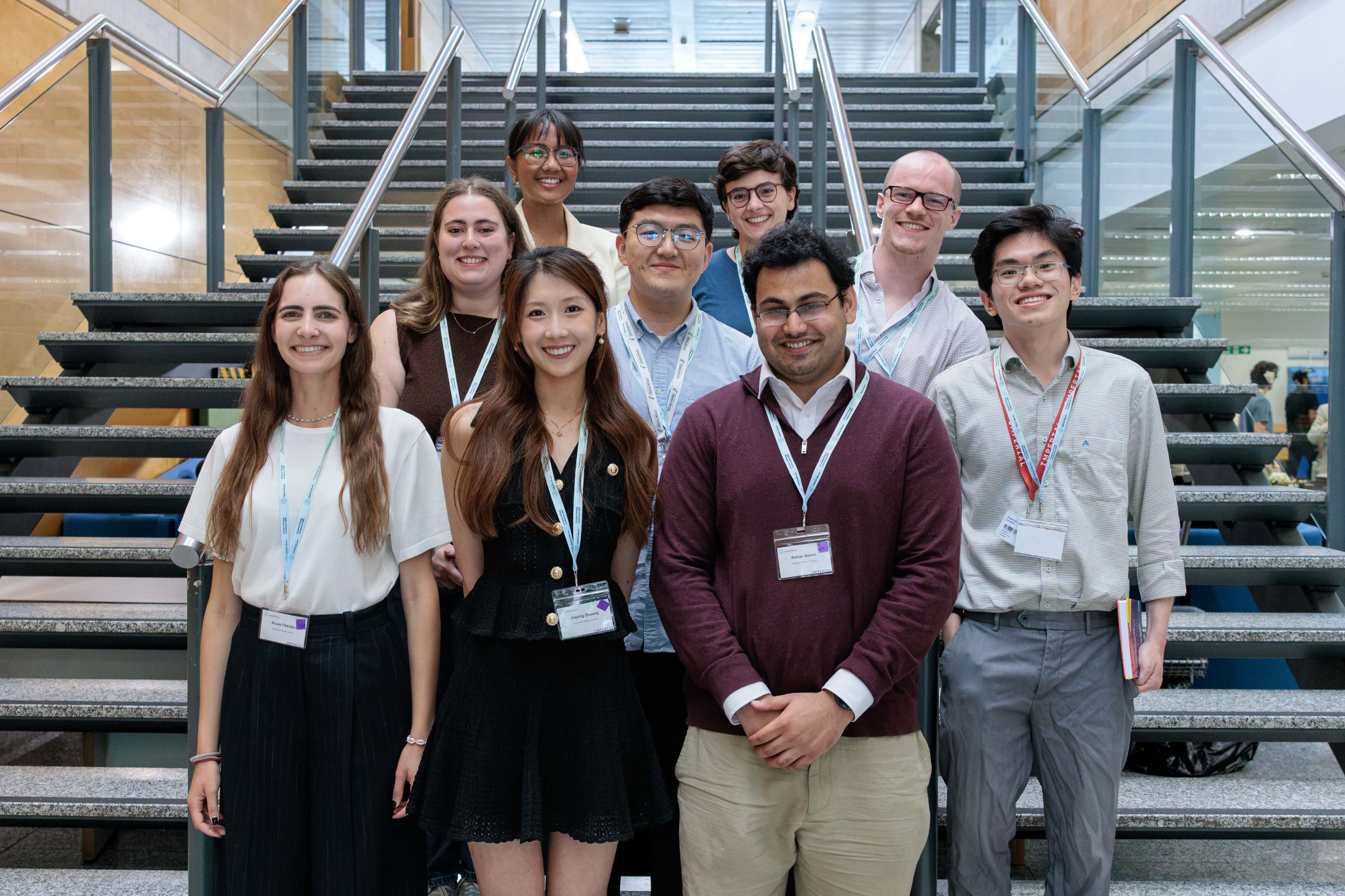 Nine students standing on stairs, smiling