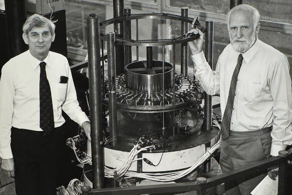 Jack Neale standing by equipment in the structures lab with colleague