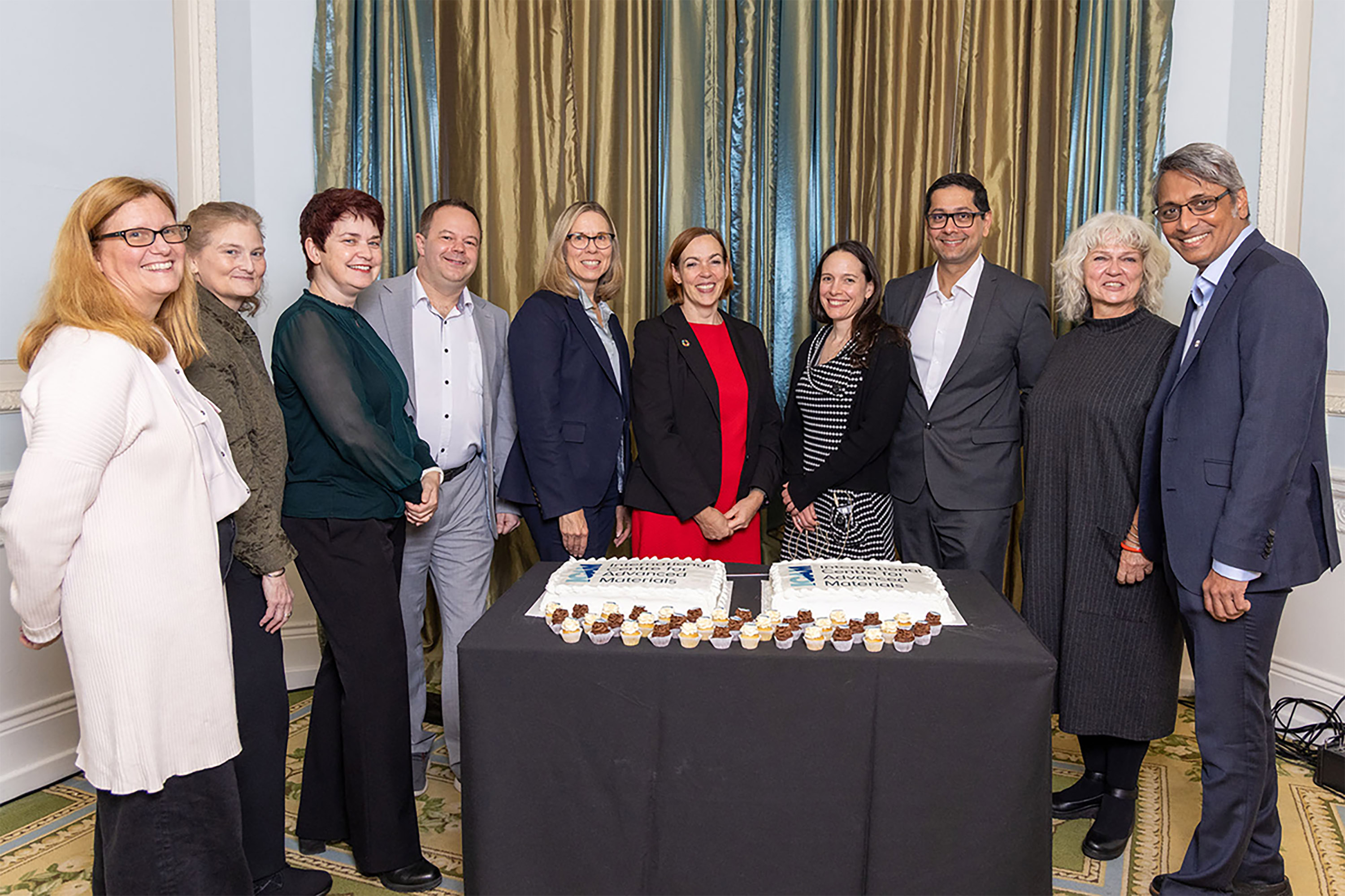 People posed behind a cake