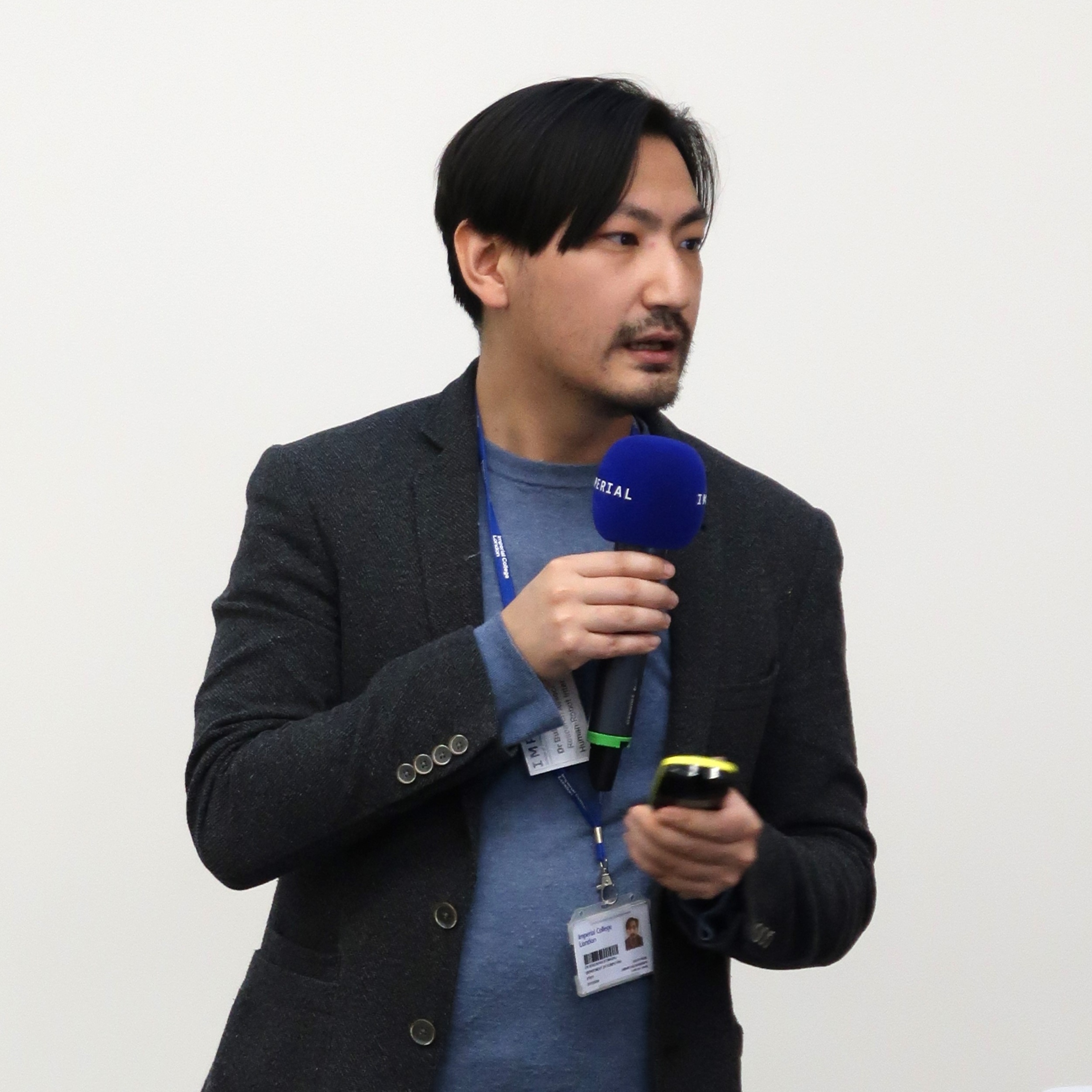 Dr Omarali speaking into a microphone