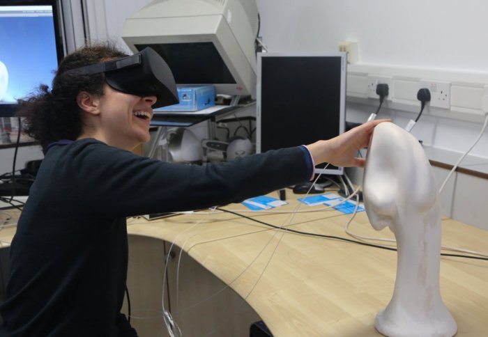 workshop participant touches the sculpture whilst wearing a virtual reality headset 