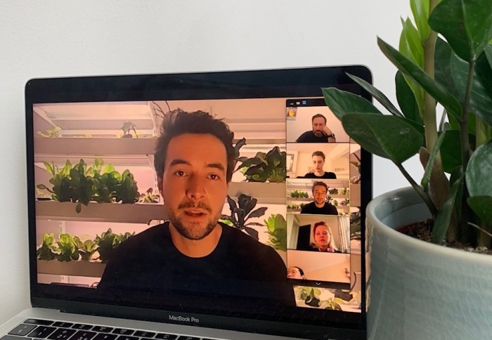 A laptop screen with a man presenting