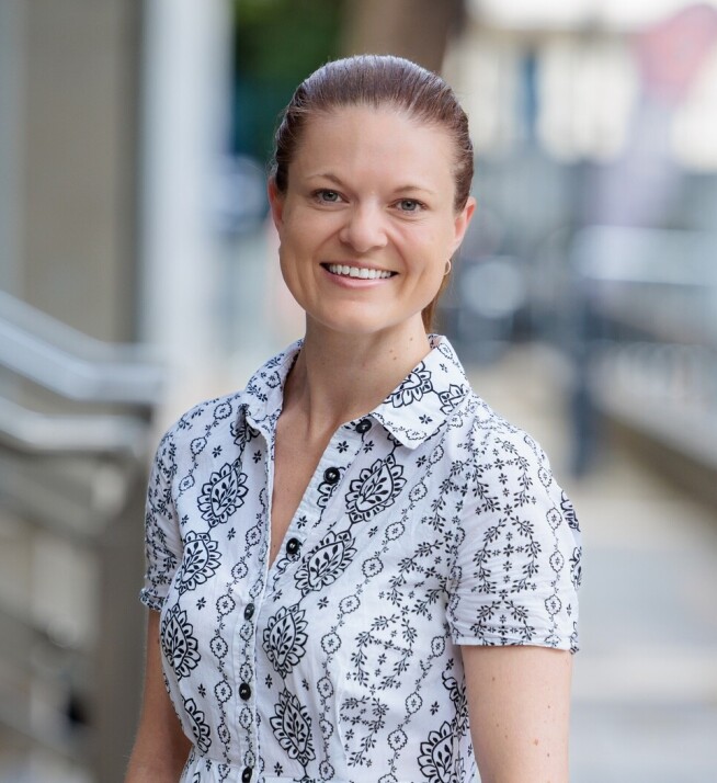 Lizzie Burrows stands in the street and smiling at the camera