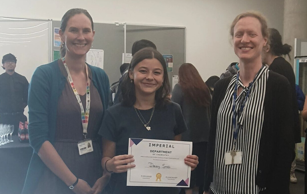 Image of student holding certificate next to professor