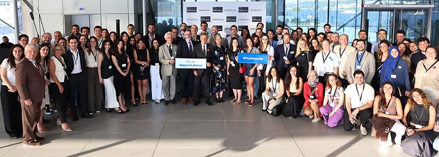 Guests at the Global Celebration in Turkey pose with banners reading 'We are Imperial alumni'