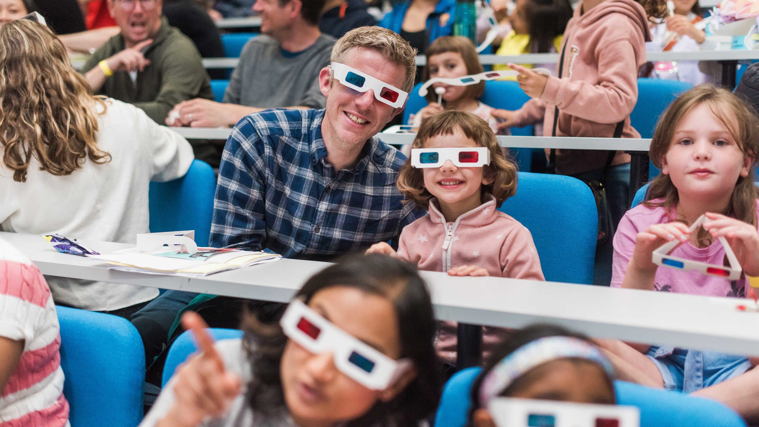 A family wear 3D glasses during a show at the Great Exhibition road Festival