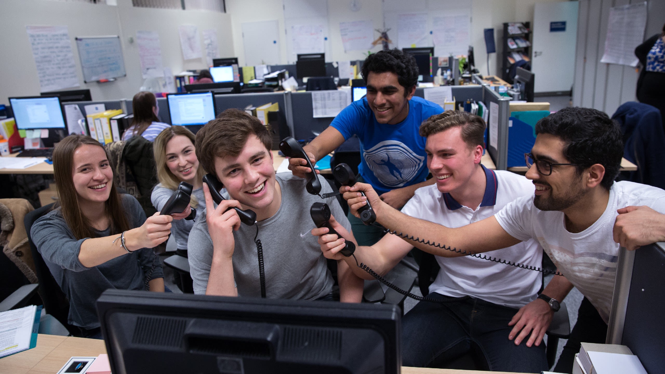 Students holding up phone receivers