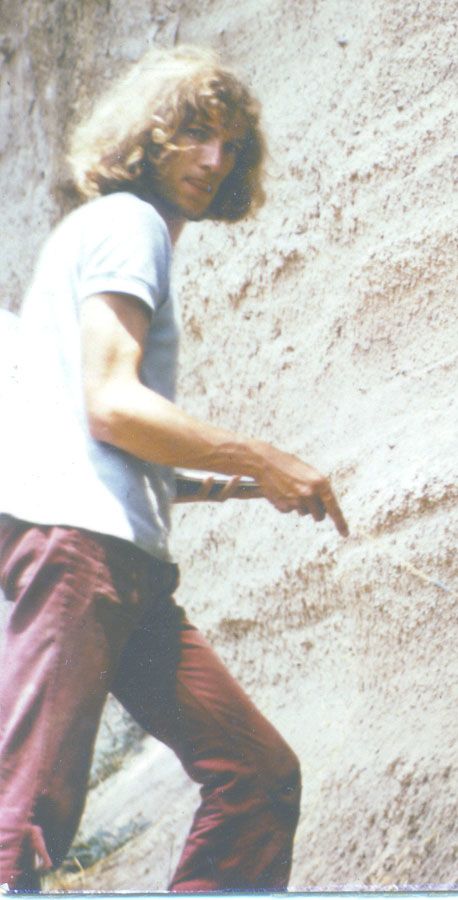 Stephen during his PhD years in Italy, standing against a rockface looking over his shoulder at the camera