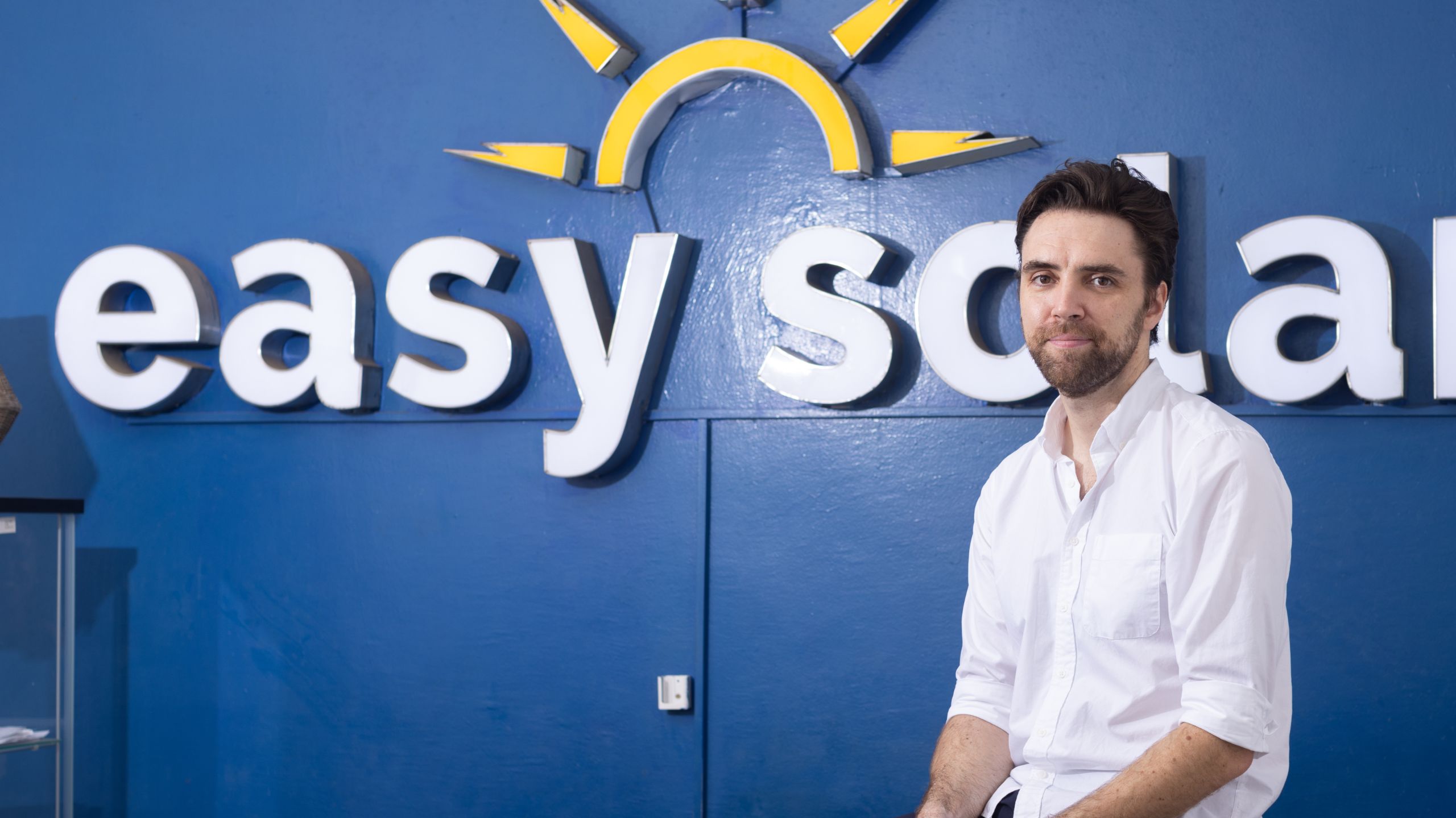 Alex Tourre in front of the easy solar sign at his office