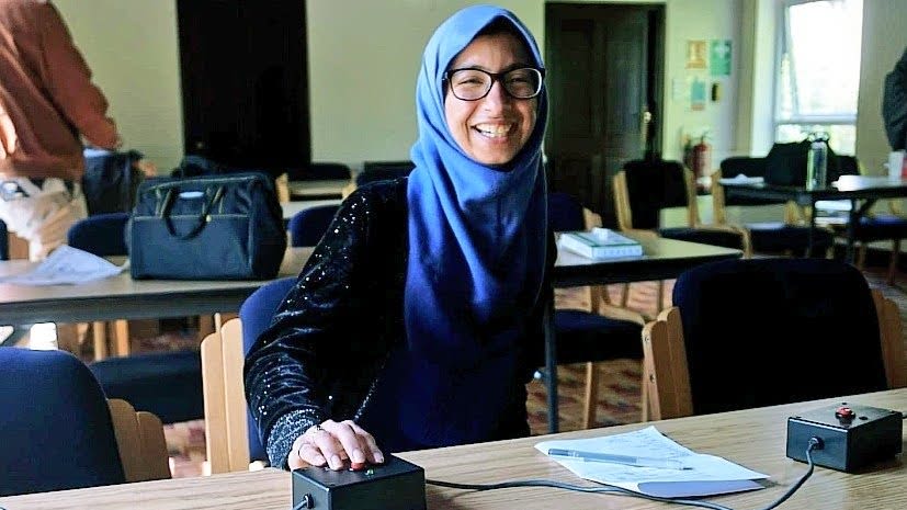 Fatima posing with a buzzer between matches at the quizbowl tournament in Oxford.