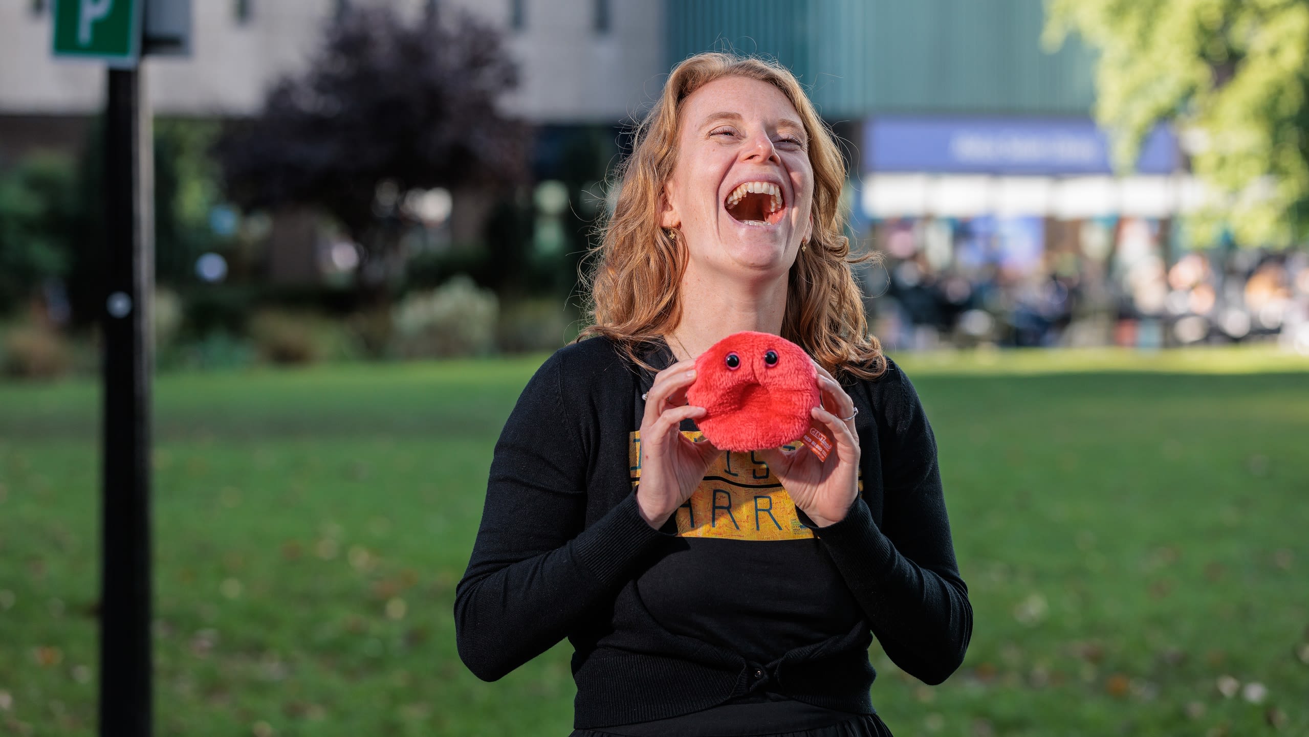 Dr Linda van Keimpema laughing, holding a soft toy model of a blood cell
