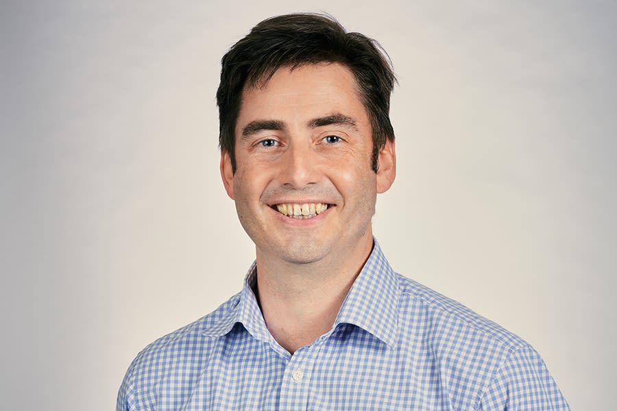 Dougal in checked shirt smiling for portrait shot